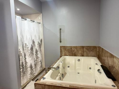 a bath tub in a bathroom with a shower curtain at Nueva Vizcaya & Suites in Hidalgo del Parral