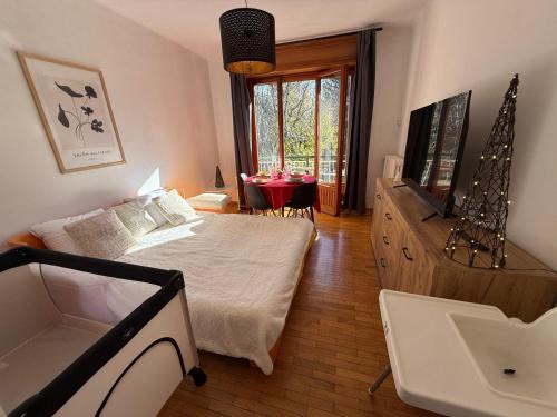 a bedroom with a bed and a television and a table at Central near station in Bardonecchia