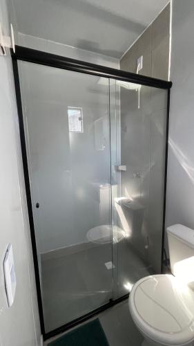 a bathroom with a glass shower with a toilet at Studio 02 Container Aeroporto in Florianópolis