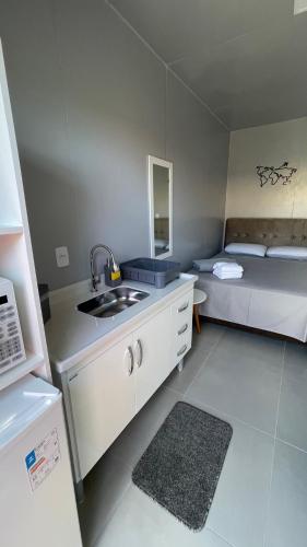 a small kitchen with a sink and a bed at Studio 02 Container Aeroporto in Florianópolis