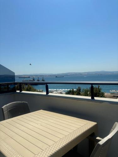 a table and chairs on a balcony with a view of the ocean at Sevez Homes in Gelibolu