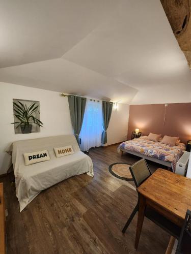 a living room with two beds and a table at Studio du moulin de Montizeau in Saint-Maigrin