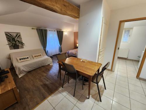 a room with a table and chairs and a bed at Studio du moulin de Montizeau in Saint-Maigrin