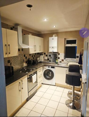 a kitchen with white cabinets and a dishwasher at Stylish Guest House in heart of Dartford Central in Dartford