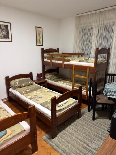 a room with four bunk beds and a table and chairs at Tim in Kalna
