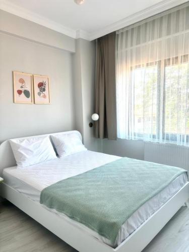 a white bedroom with a large bed with a window at Sevez Homes in Gelibolu