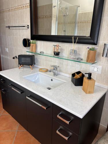 a bathroom counter with a sink and a mirror at Casa PerlAmbra Abruzzo in Casagreca