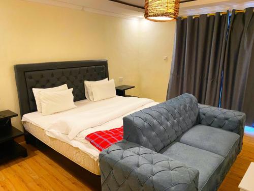 a bedroom with a bed and a couch at The gorilla hideout in Ruhengeri