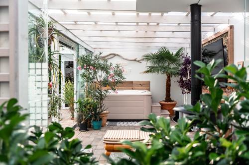 a patio with potted plants and a bath tub at Orbisa Bis w cenie Basen podgrzewany Sauna Jacuzzi Rowery Parking Klimatyzacja Opcja śniadań in Łeba