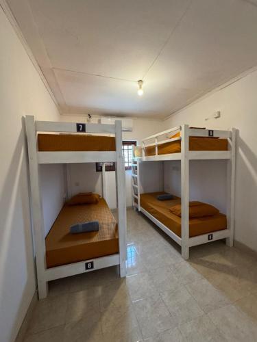 a room with three bunk beds in a room at Rose Apple Hostel in Ahangama
