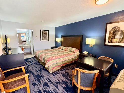 a hotel room with a bed and a desk at Scottish Inns Westcott Street in Houston