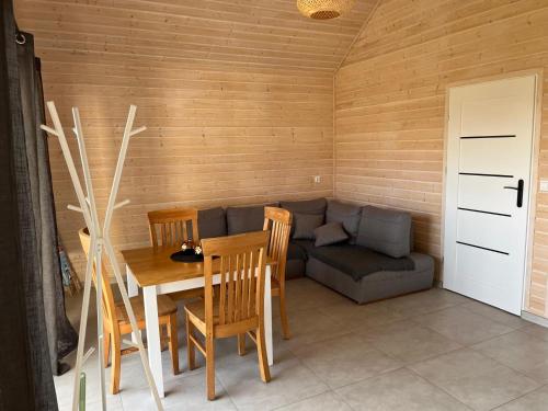 a living room with a table and a couch at Domki BAMBINO in Sarbinowo