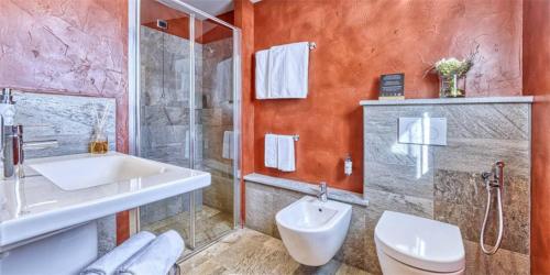 ein Badezimmer mit Toilette, Waschbecken und Dusche in der Unterkunft Hotel Sant'Orso - Mountain Lodge & Spa in Cogne