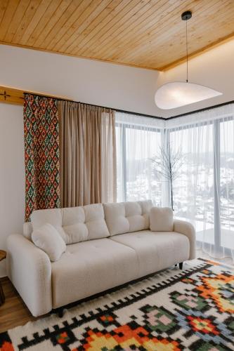 a white couch in a living room with a large window at Vershok villa in Slavske
