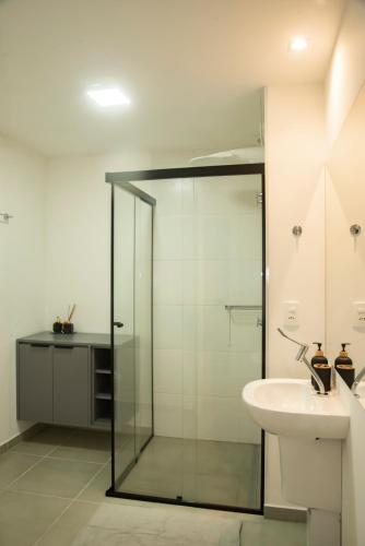 a bathroom with a glass shower and a sink at Essential comfort - Vila Mariana in São Paulo