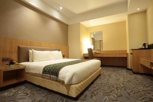 クチンにあるインペリアル リバーバンク ホテル クチンのベッドとバスルーム付きのホテルルームです。