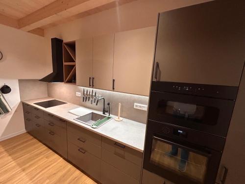 a kitchen with a sink and a stove top oven at Apartmánový dom DK Ateliér in Dolný Kubín