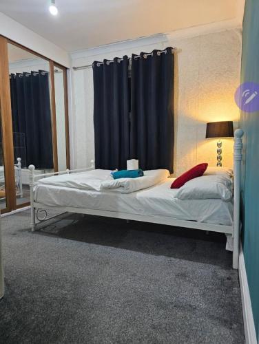 a bedroom with a bed and a window with curtains at Stylish Guest House in heart of Dartford Central in Dartford