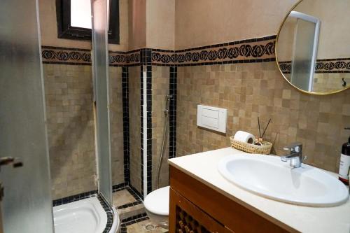 a bathroom with a sink and a toilet and a mirror at Stylish Apartment with Pool in Marrakech in Marrakesh