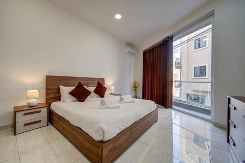 a bedroom with a large bed and a large window at Central Oasis - Private Pool & Lounge Area in Santa Vennera