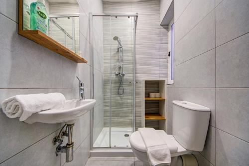 a bathroom with a toilet and a sink and a shower at Central Oasis - Private Pool & Lounge Area in Santa Vennera