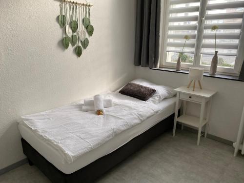 a bedroom with a bed with a table and a window at Ferienwohnung in Solingen Innenstadt in Solingen