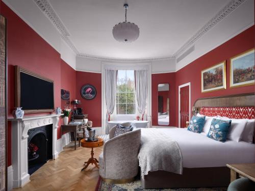 a bedroom with red walls and a bed and a fireplace at Bertrand's Townhouse in London