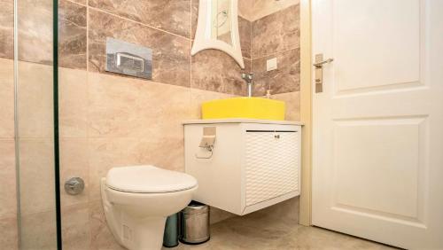 a bathroom with a white toilet and a sink at Villa Adalya in Kaş