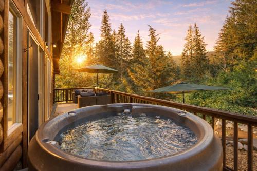 a hot tub on the balcony of a house at Raven Haven Lodge by NW Comfy Cabins in Leavenworth
