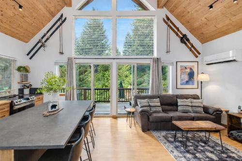 a living room with a large window and a couch at Raven Haven Lodge by NW Comfy Cabins in Leavenworth