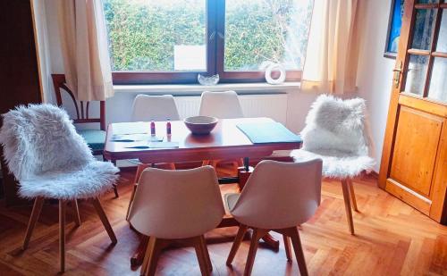 a dining room with a table and chairs with white seats at Landhaus Eva-Maria in Elbingerode