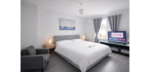 a bedroom with a bed and a tv and a couch at The Dene Homestay in Drogheda