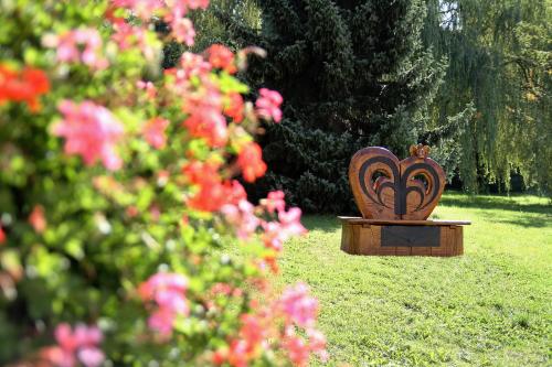 a bench sitting in the grass with pink flowers at Zámek Havířov in Havířov