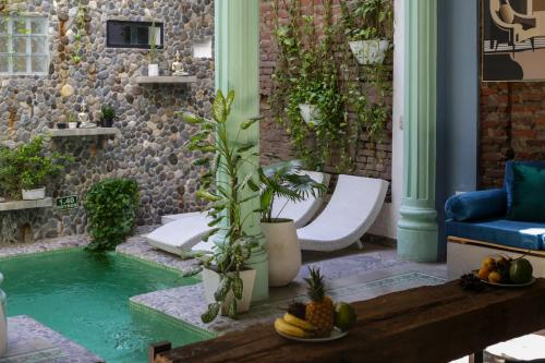 a swimming pool in the middle of a patio with a couch and a table at Casa Verde Boutique Hotel in Santa Marta