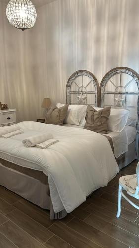 a bedroom with a large bed with white sheets and pillows at Trulli Enjoy in Noci