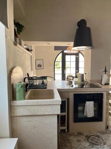 a kitchen with a large sink and a stove at Trulli Enjoy in Noci