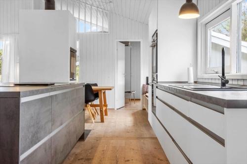 a kitchen with white walls and a wooden floor at 931-Thisted-Pinbak-24 in Torsted
