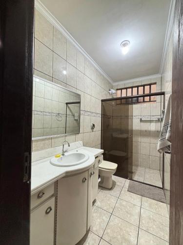a bathroom with a sink and a toilet and a shower at Econômica Joinville Hostel e Pousada in Joinville