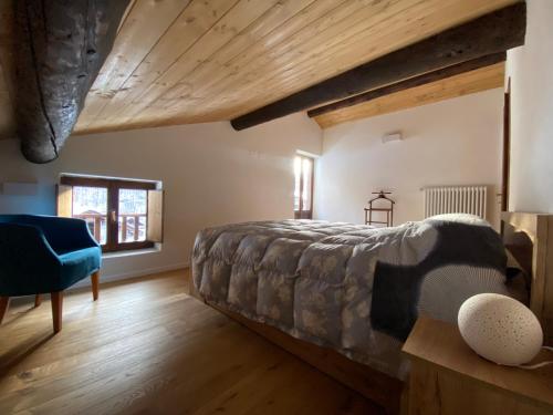 a bedroom with a bed and a blue chair at Villa Vetto in Lanzada