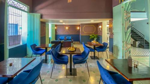 a dining room with blue chairs and tables at Casa Verde Boutique Hotel in Santa Marta