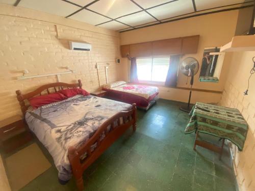 a bedroom with two beds and a fan at Apartamentos Quintana in Santa María