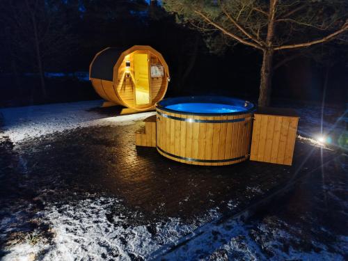 a wooden tub sitting next to a tree in the snow at Chata Sosenka in Sygontka