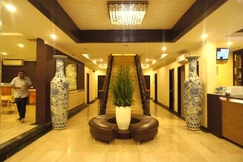 a lobby with two large vases and a couch at Sky View Hotel Managed by OS in Batam Center
