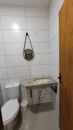 a bathroom with a white toilet and a sink at Cantinho do sossego in Capão da Canoa