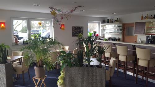 a restaurant with potted plants and a bar at Hotel Beuss in Oberursel