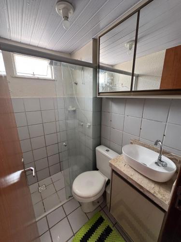 a bathroom with a toilet and a sink and a mirror at Apartamento confortável in São Luís
