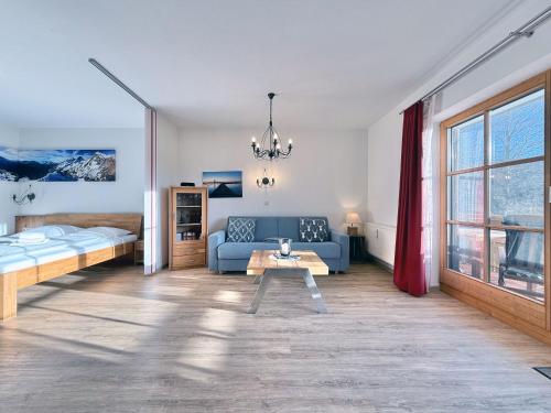 a living room with a couch and a bed and a table at Sonnenhof Seeg 05 in Seeg