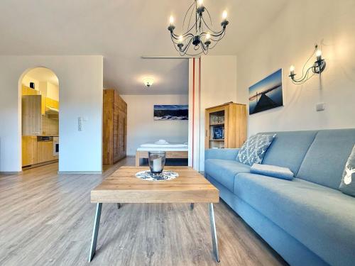 a living room with a blue couch and a table at Sonnenhof Seeg 05 in Seeg