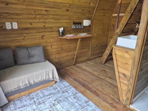 a small room with a bed and a sink at Chalé solmar in Penha