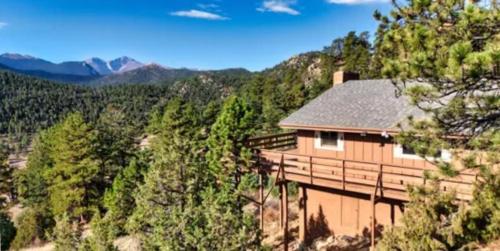 a house on the side of a hill with trees at Rocky Mountain Panorama Cabin in Estes Park